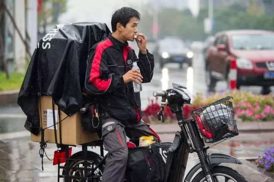 似乎感到一丝焦虑看着窗外的飞雪,想到远方的妻儿快递员小李今年春节