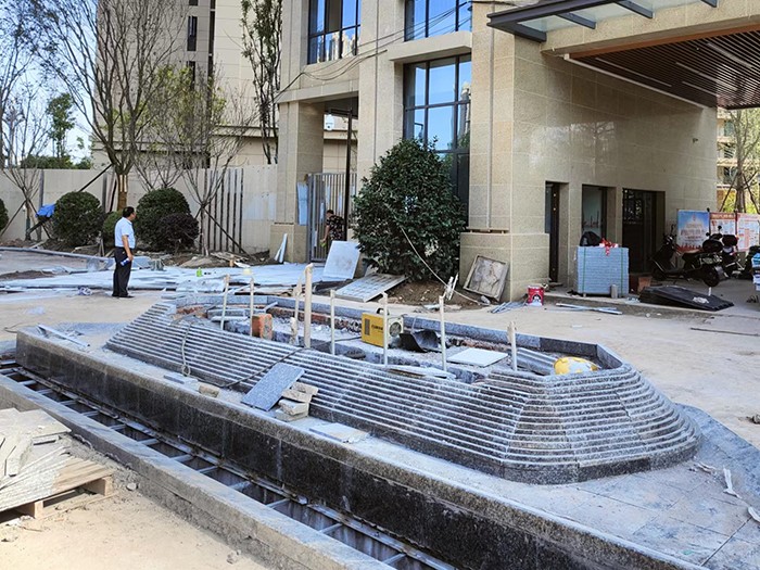 主入口外的喷泉水景中庭实景小区围栏已经建好,工人们正在铺设沿街