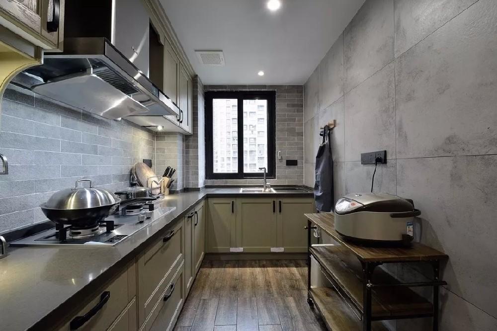 厨房采用了灰色小砖跟灰绿色橱柜和黑色台面的搭配，营造出满满的复古味。